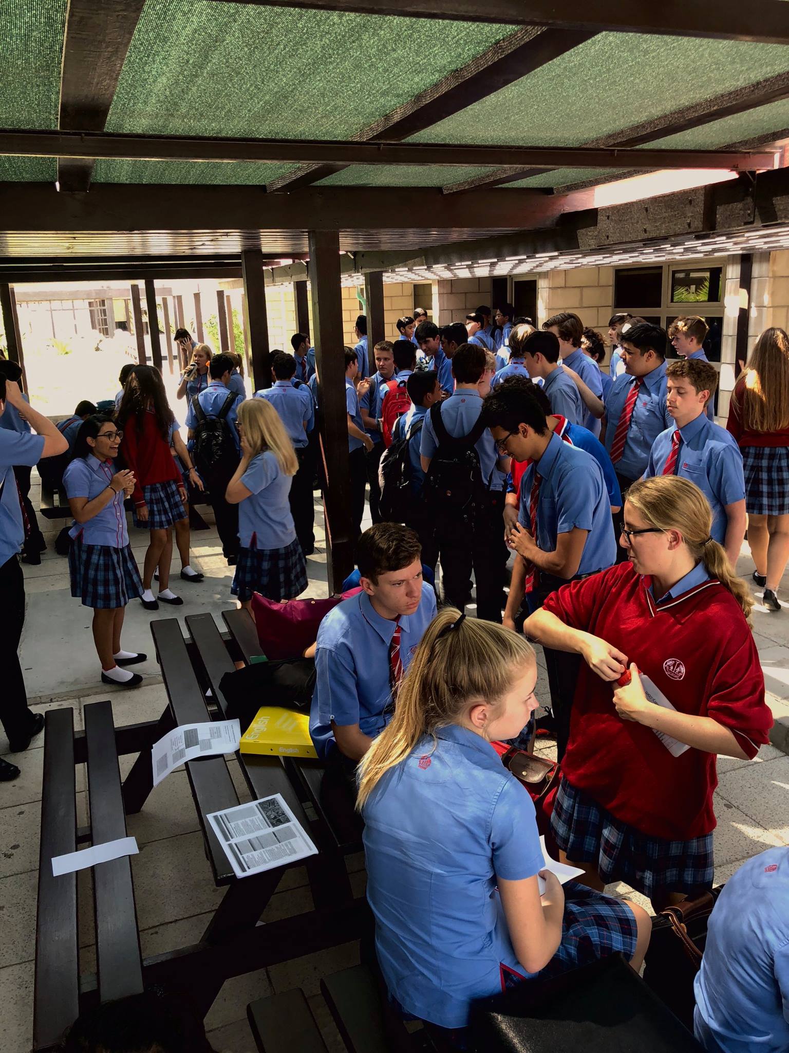 Break Time: 'The hustle of busy break time. A hub for year 11 activity at second breaks is this small area in front of the DT block; though very busy and sometimes slightly crowded, it is an area where a lot of year 11 convene to catch up with many they would most probably not talk to on a normal day!'